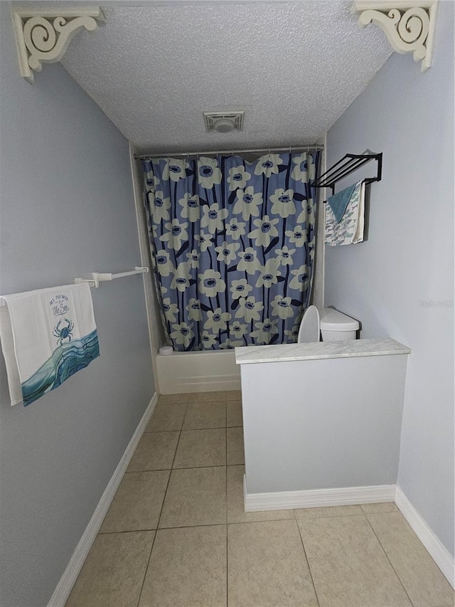 13813 Mission Oaks Blvd, Seminole, FL 33776 - full bathroom featuring tile patterned floors, a textured ceiling, a shower with curtain, toilet, and visible vents