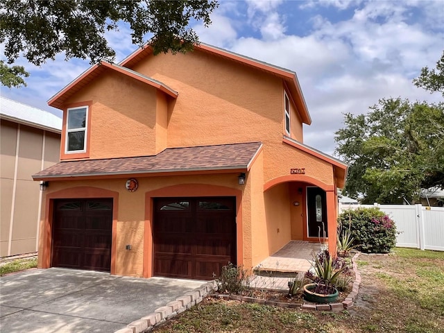 5207 Moeller Ave, Sarasota, FL 34233 - view of front of house with driveway, a garage, stucco siding, and fence