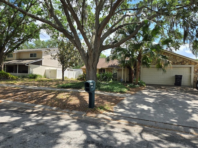 view of front of home featuring concrete driveway, fence, and an attached garage