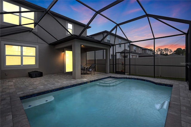 19926 Stone Pine Cir, Lutz, FL 33558 - pool at dusk featuring a patio area, fence, and a lanai