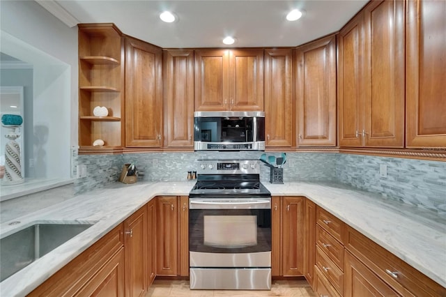 kitchen with light stone countertops, brown cabinets, open shelves, and appliances with stainless steel finishes