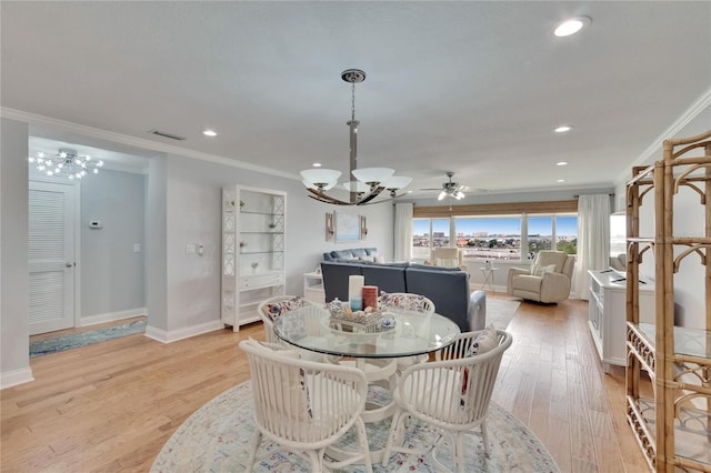 dining area with light wood-type flooring, a notable chandelier, ornamental molding, and baseboards