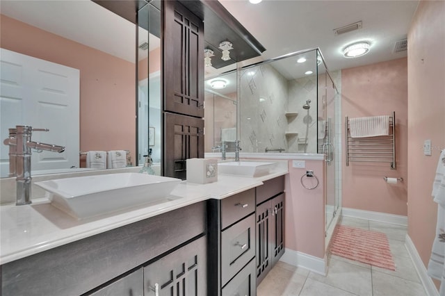 bathroom featuring tile patterned flooring, visible vents, a sink, a stall shower, and double vanity