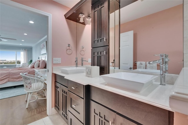 ensuite bathroom with a sink, ensuite bathroom, ceiling fan, and double vanity