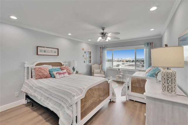 bedroom with crown molding, light wood finished floors, and baseboards