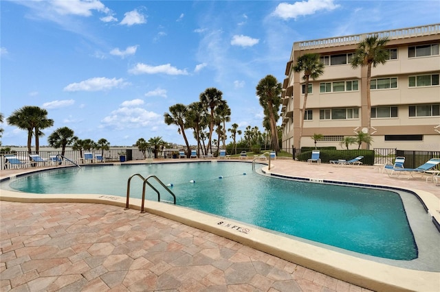 pool with a patio area and fence