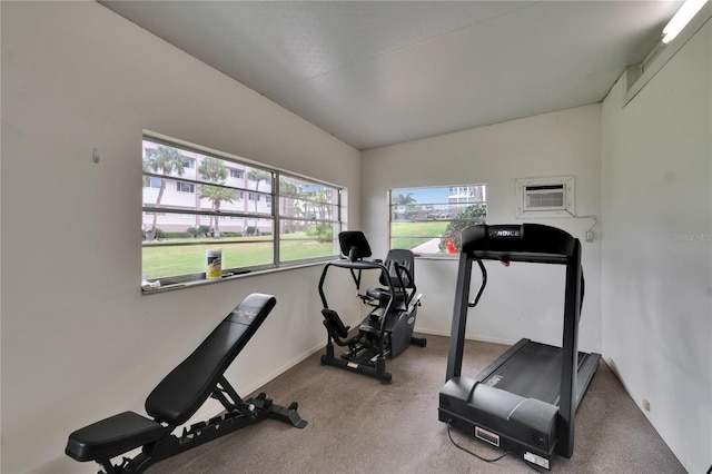 workout room featuring an AC wall unit, baseboards, carpet floors, and lofted ceiling
