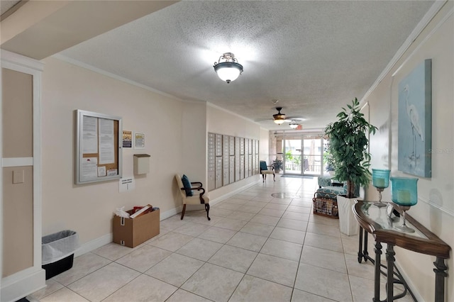 corridor with baseboards, a textured ceiling, crown molding, and light tile patterned flooring