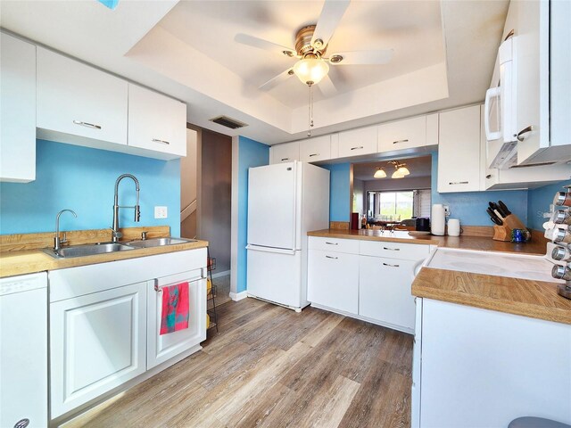 1500 Sunset Rd Unit C7, Tarpon Springs, FL 34689 - kitchen featuring white appliances, a tray ceiling, a sink, a ceiling fan, and light wood-type flooring