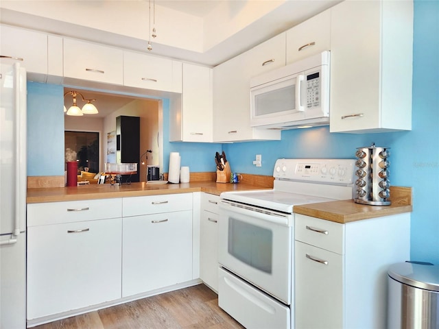 1500 Sunset Rd Unit C7, Tarpon Springs, FL 34689 - kitchen with white appliances, light countertops, white cabinets, and light wood-style flooring