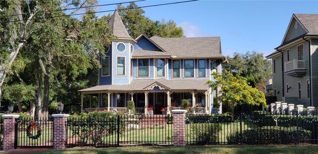 1500 Sunset Rd Unit C7, Tarpon Springs, FL 34689 - victorian-style house featuring covered porch, a fenced front yard, and a shingled roof