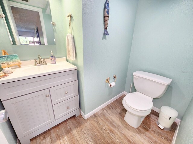 1500 Sunset Rd Unit C7, Tarpon Springs, FL 34689 - half bathroom with wood finished floors, toilet, baseboards, and vanity