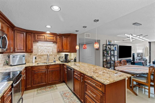 220 Belleview Blvd Unit 104, Belleair, FL 33756 - kitchen featuring stainless steel appliances, a peninsula, light stone countertops, a textured ceiling, and backsplash