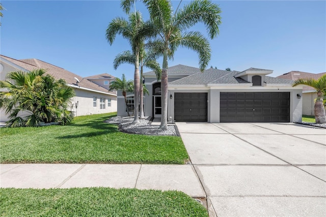 ranch-style house with a front yard, a shingled roof, a garage, concrete driveway, and stucco siding