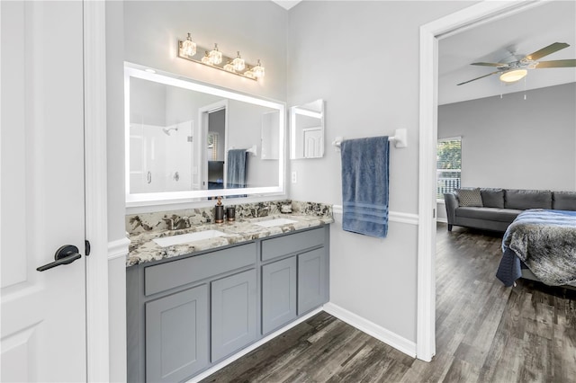ensuite bathroom with a sink, ensuite bathroom, a ceiling fan, and wood finished floors