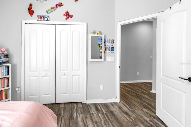 bedroom with a closet, baseboards, and wood finished floors