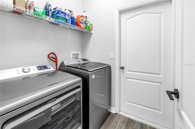 clothes washing area featuring dark wood-type flooring, laundry area, and washing machine and dryer