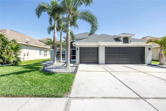view of front facade featuring a front yard, a shingled roof, a garage, stucco siding, and driveway