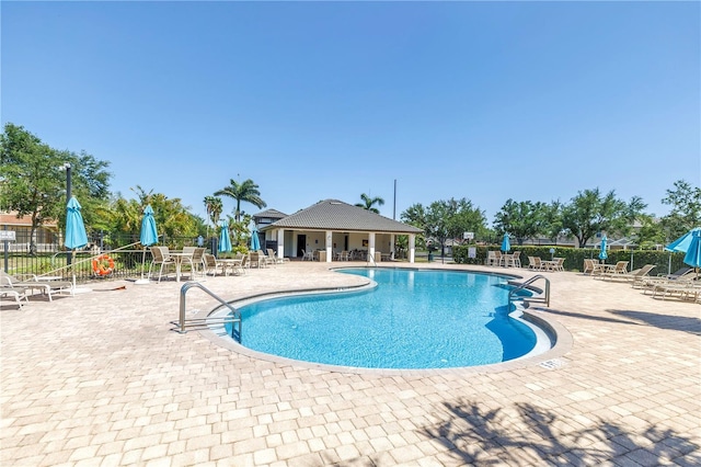 community pool featuring a patio area and fence
