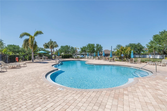 community pool featuring a patio and fence