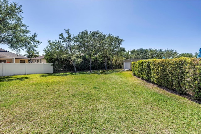 view of yard with a garage, an outdoor structure, and fence