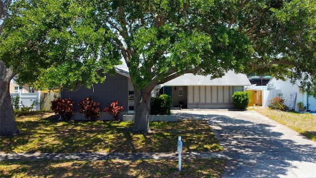 ranch-style house featuring fence and driveway