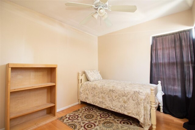 bedroom featuring lofted ceiling, wood finished floors, and ceiling fan