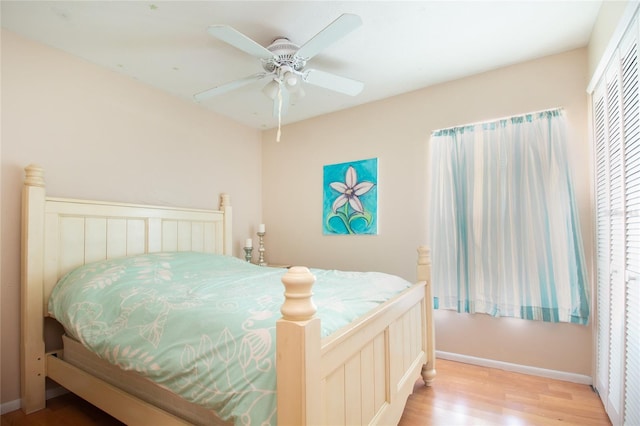 bedroom with light wood-style floors, baseboards, and a ceiling fan
