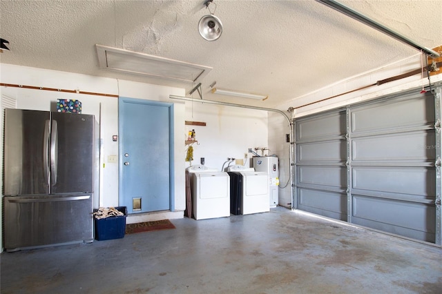 garage with washing machine and clothes dryer, freestanding refrigerator, and water heater