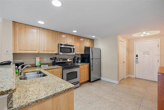 11605 Gulf Blvd Unit 203, Treasure Island, FL 33706 - kitchen featuring appliances with stainless steel finishes, a sink, baseboards, light brown cabinets, and light tile patterned flooring