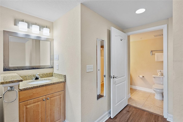 11605 Gulf Blvd Unit 203, Treasure Island, FL 33706 - bathroom featuring toilet, vanity, baseboards, and wood finished floors