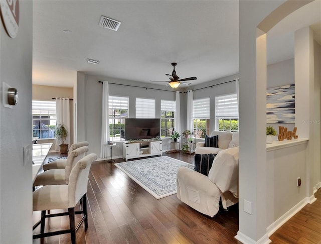 20537 Lace Cascade Rd, Land O Lakes, FL 34637 - living room featuring dark wood finished floors, ceiling fan, arched walkways, and baseboards