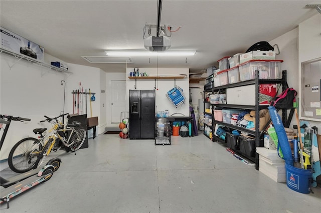 20537 Lace Cascade Rd, Land O Lakes, FL 34637 - garage featuring black refrigerator with ice dispenser, a garage door opener, and electric panel