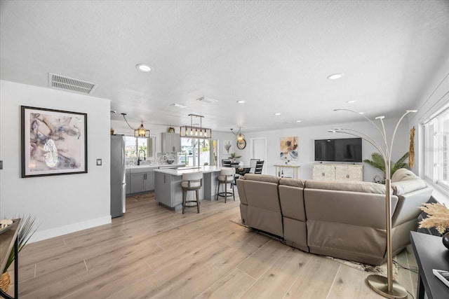 7889 3rd Ave S, Saint Petersburg, FL 33707 - living room featuring light wood-style floors, recessed lighting, and baseboards