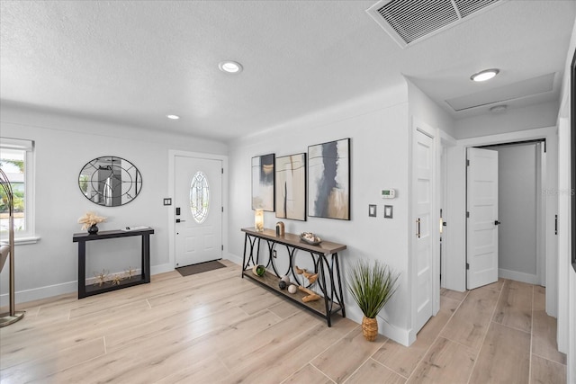 7889 3rd Ave S, Saint Petersburg, FL 33707 - foyer entrance with light wood-type flooring, baseboards, recessed lighting, and a textured ceiling