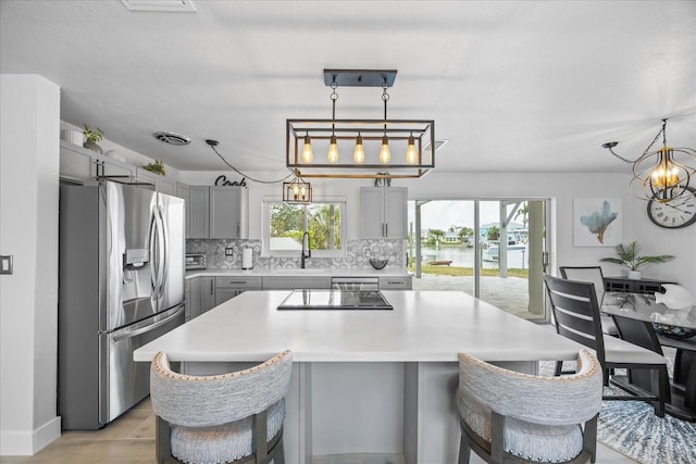 7889 3rd Ave S, Saint Petersburg, FL 33707 - kitchen with stainless steel fridge, gray cabinets, a sink, and plenty of natural light