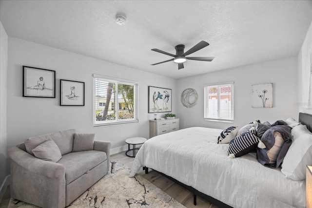 7889 3rd Ave S, Saint Petersburg, FL 33707 - bedroom featuring wood finished floors, baseboards, a textured ceiling, and a ceiling fan