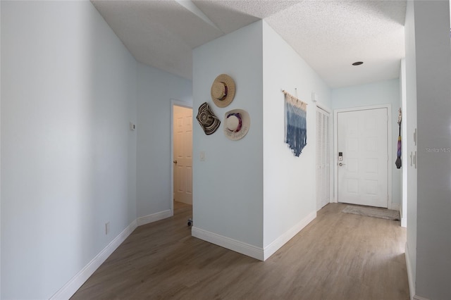 corridor with wood finished floors and baseboards