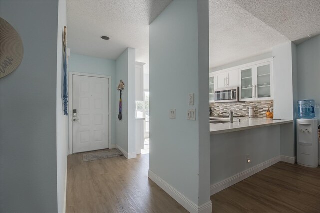 entrance foyer featuring baseboards, wood finished floors, and a textured ceiling