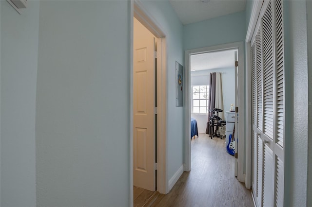 corridor with baseboards and light wood-type flooring