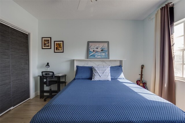 bedroom with wood finished floors, a closet, and ceiling fan