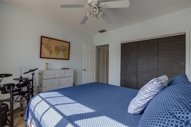 bedroom featuring a closet, visible vents, a ceiling fan, and light wood finished floors