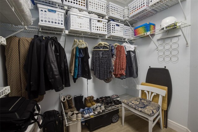 walk in closet with wood finished floors