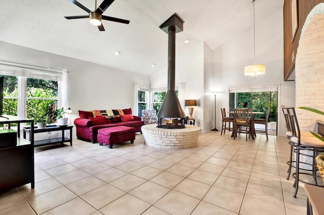 13902 Bardmoor Pl Unit B, Tampa, FL 33618 - living room featuring light tile patterned flooring, a wood stove, high vaulted ceiling, a ceiling fan, and a textured ceiling