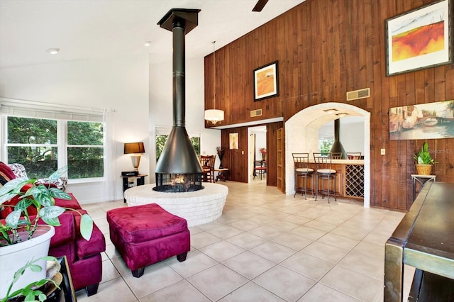 13902 Bardmoor Pl Unit B, Tampa, FL 33618 - tiled living room featuring high vaulted ceiling, a wood stove, and wood walls