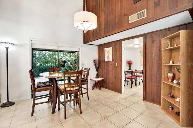 13902 Bardmoor Pl Unit B, Tampa, FL 33618 - dining space featuring a towering ceiling, wood walls, light tile patterned floors, and baseboards