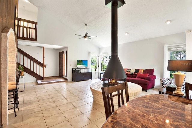 13902 Bardmoor Pl Unit B, Tampa, FL 33618 - dining area with light tile patterned flooring, ceiling fan, stairs, vaulted ceiling, and baseboards