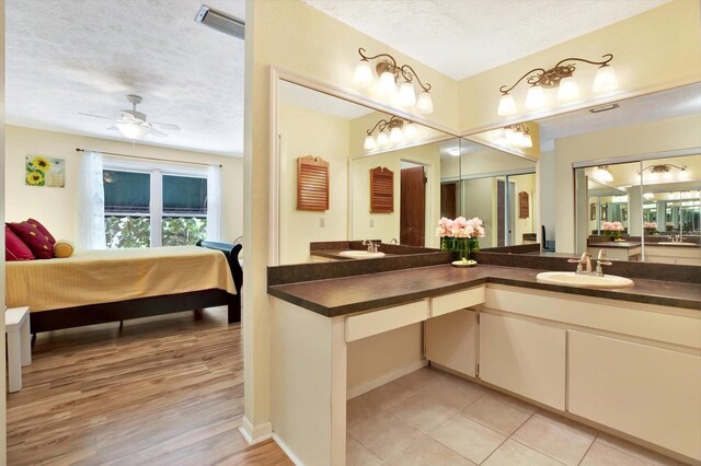 13902 Bardmoor Pl Unit B, Tampa, FL 33618 - full bath with ensuite bath, a textured ceiling, double vanity, a ceiling fan, and wood finished floors