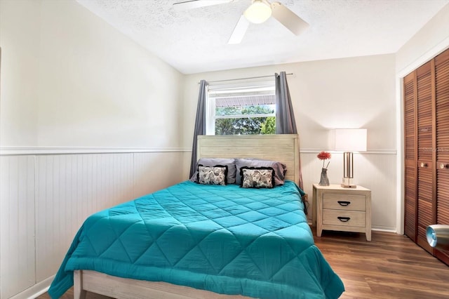 13902 Bardmoor Pl Unit B, Tampa, FL 33618 - bedroom featuring a closet, wood finished floors, wainscoting, a textured ceiling, and ceiling fan