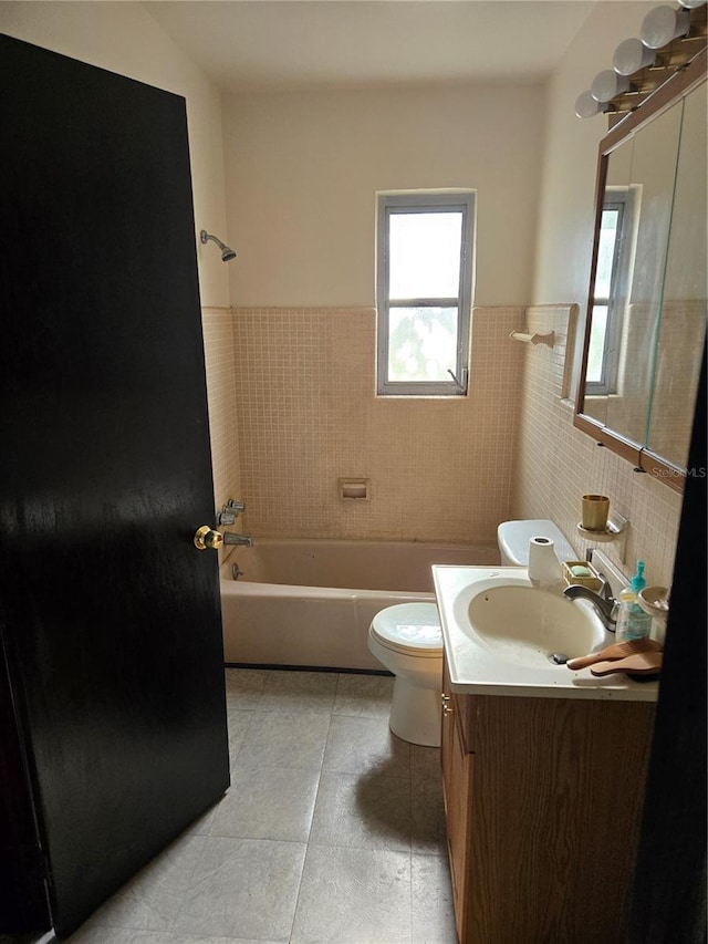 1125 Engman St, Clearwater, FL 33755 - bathroom featuring vanity, toilet, washtub / shower combination, a wainscoted wall, and tile patterned floors